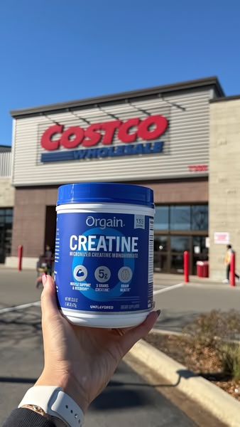 A close-up POV shot of a customer holding a container of creatine in front of a recognizable grocery store entrance.